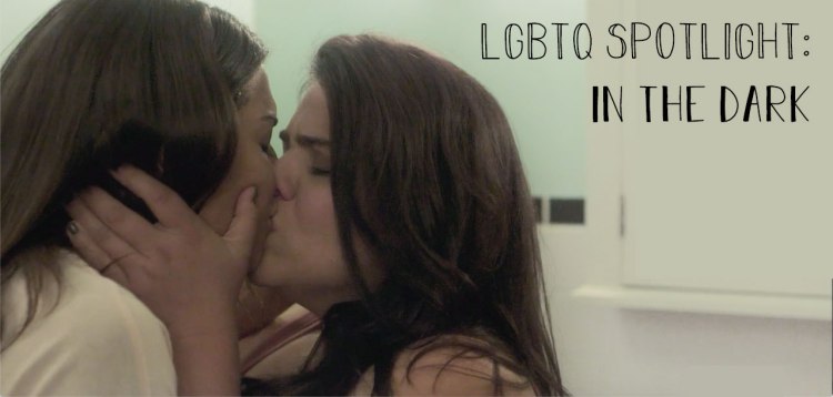 Jess, from In the Dark, kisses another woman. The title reads, LGBTQ spotlight, in the dark.